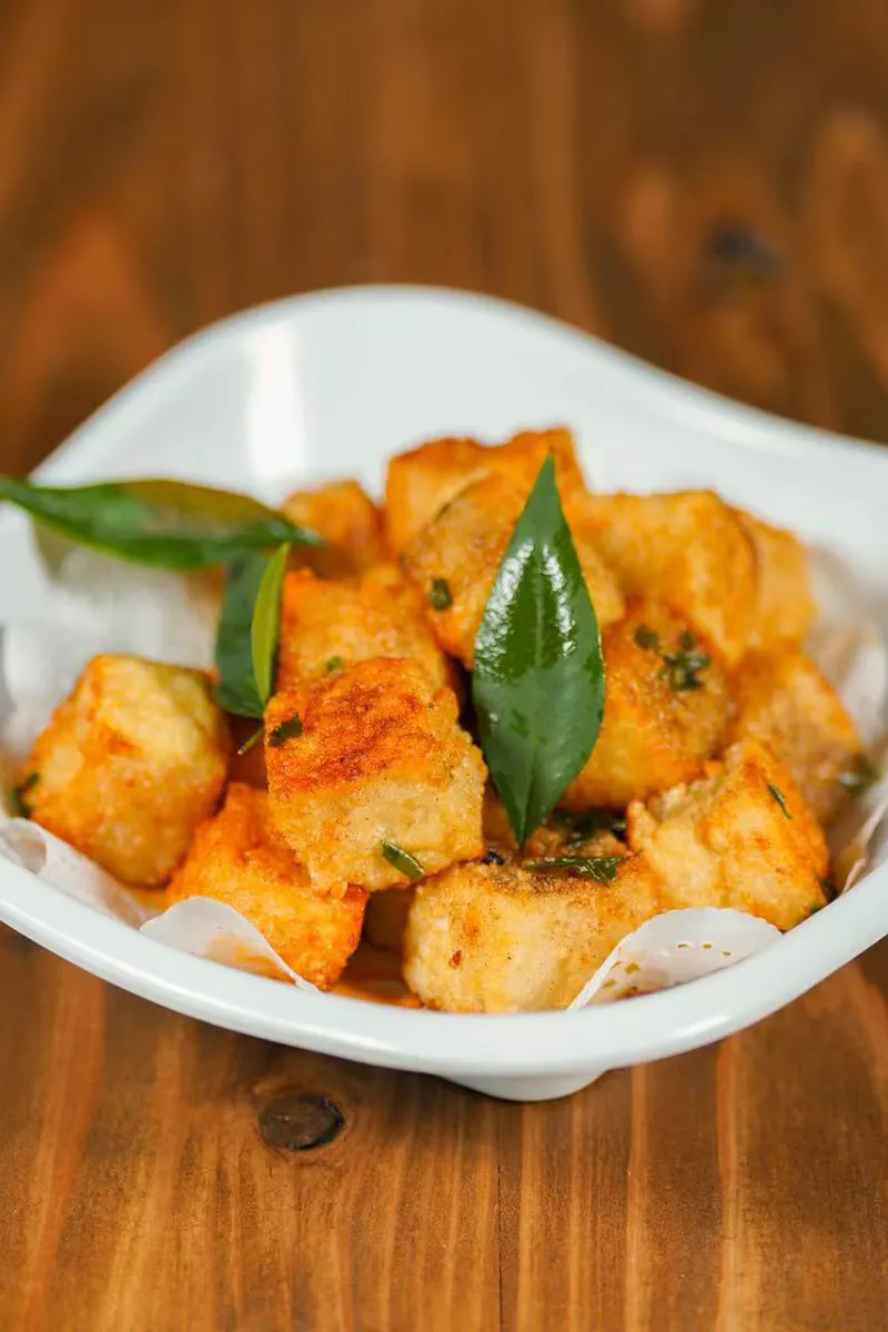 Crispy pan fried tofu cubes garnished with fresh aromatic herb leaves at One More Bite Dumpling, a Chinese Restaurant in Yucaipa